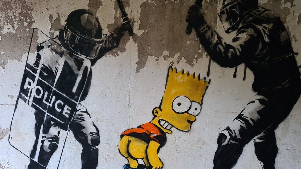 photo of graffiti showing Bart Simpson mooning police officers